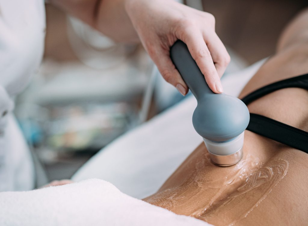 Ultrasound in Physical Therapy. Therapist Using Ultrasound Applicator on a Patient's Lower Back